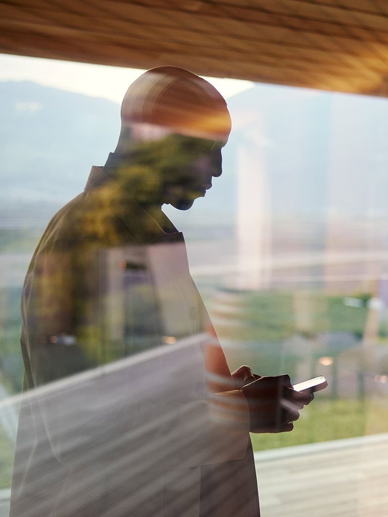 Man with smartphone behind a window